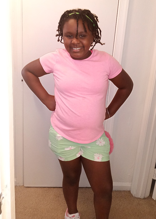 Young African American girl smiling at the camera.