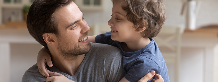 Dad and young son hug.