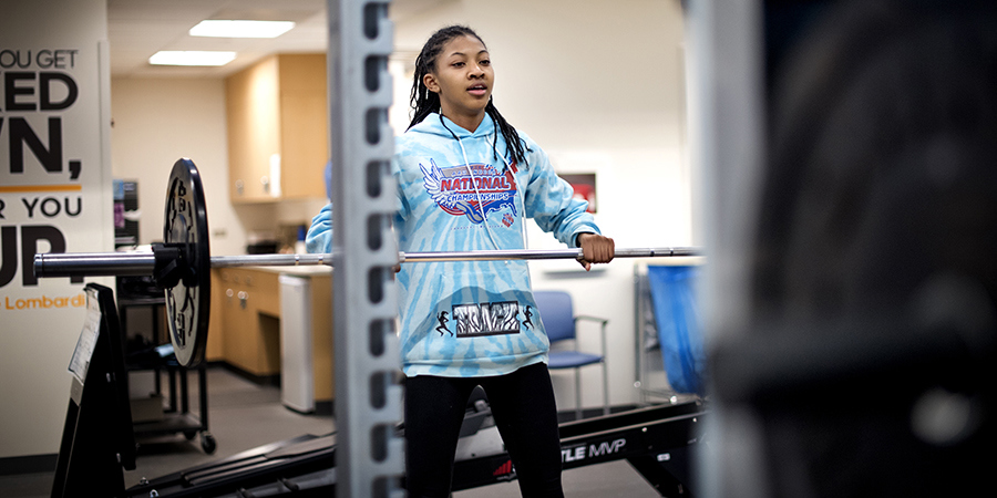 Teen girl lifting weights at the CHKD Sports Medicine gym in Virginia Beach.