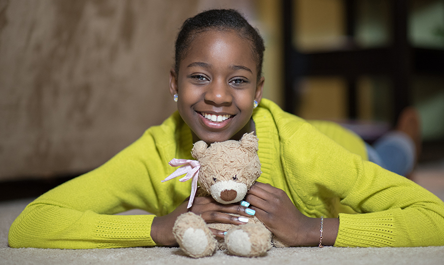 Sickle cell patient smiling with her teddy bear