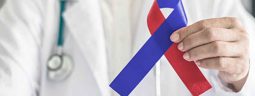 Red and blue ribbon in medical doctor's hand for Congenital Heart Defects Awareness