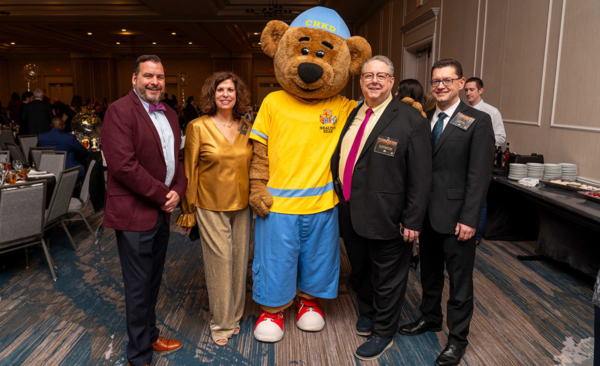 CHKD Leadership and Key Staff Gather for a Group Photo with Healthy Bear at the 2024 Milestone Gala.