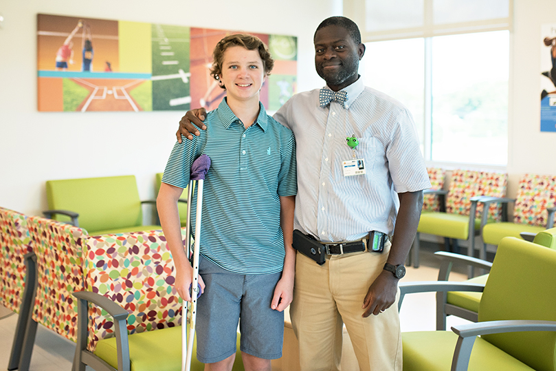 Conrad Lehmkuler and Dr. St. Remy gather for a photo in our orthopedic surgery and sports medicine waiting room.