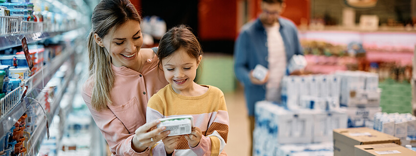 Mother and daughter reviewing food label in grocery store
